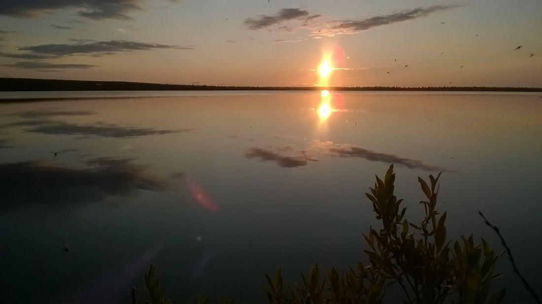 Auringon lasku tyynellä tunturijärvellä.