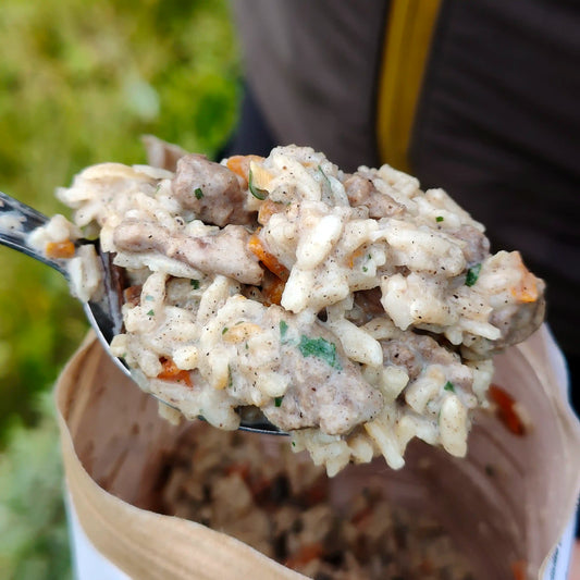 Härkäpataa riisillä ja sienillä retkiruokaa valmiina lusikassa.