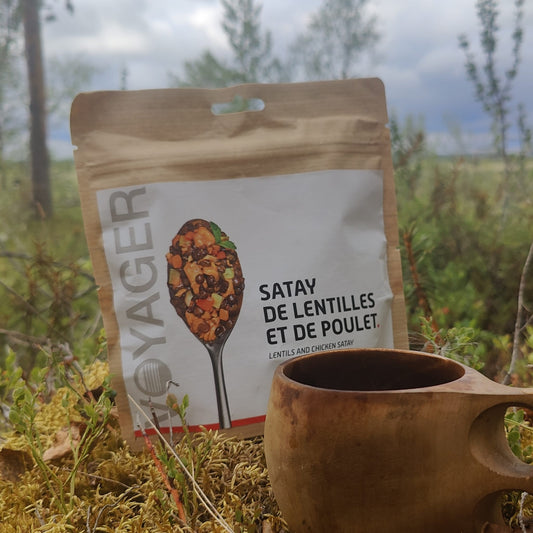 Kana-linssisatay retkiruokapussi sammaleisessa maassa kuksan kanssa.