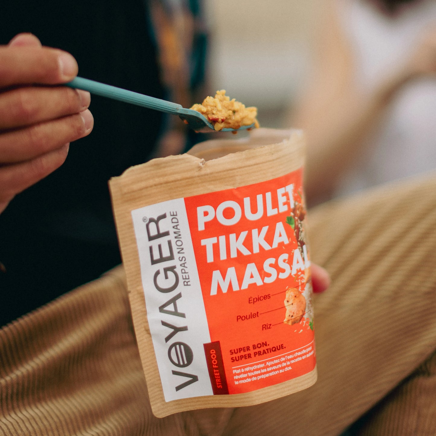 Retkiruokapussi kana tikka masala istuvan imisen kädessä, valmista ruokaa haarukassa