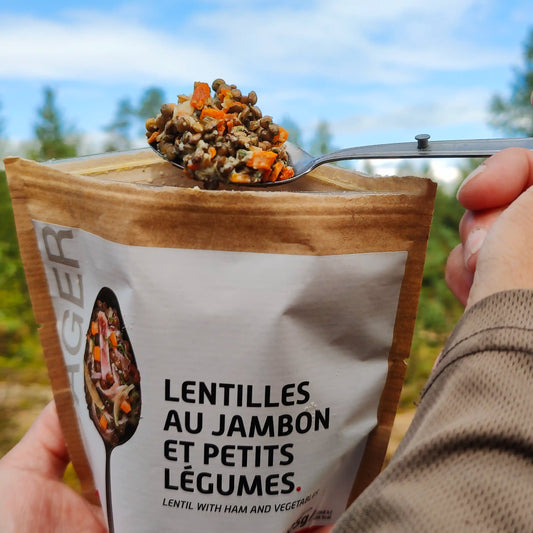 Linssipataa kinkulla ja kasviksilla retkiruokapussi kädessä ja lusikassa valmiina.