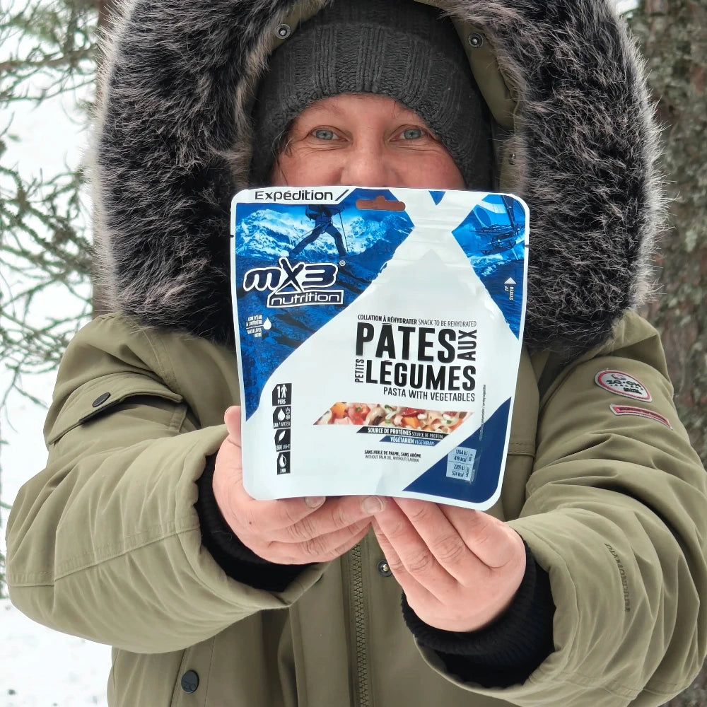 Kasvispasta retkiruokapussi vihreätakkisen naisen kädessä talvella.