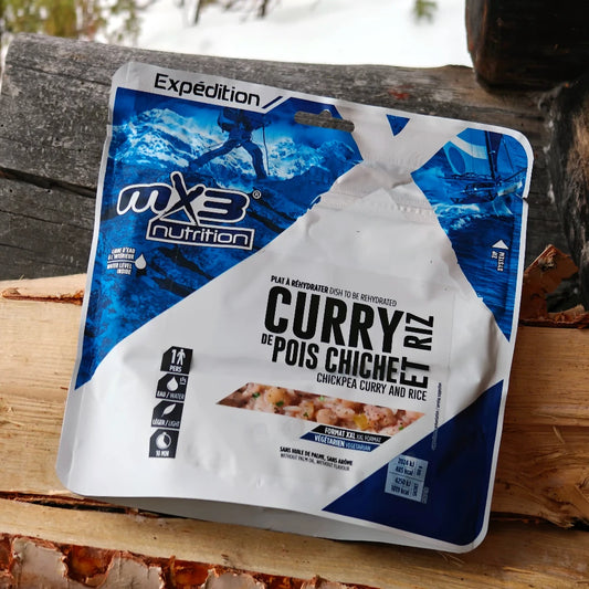 Retkiruokapussi kikhernecurry halkojen päällä.