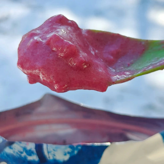 Retkiruoka jälkkäri vadelmamousse valmiina vihreässä lusikassa.