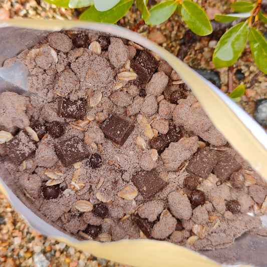 Suklaa-granolamysli retkiruokapussi avattuna maassa.