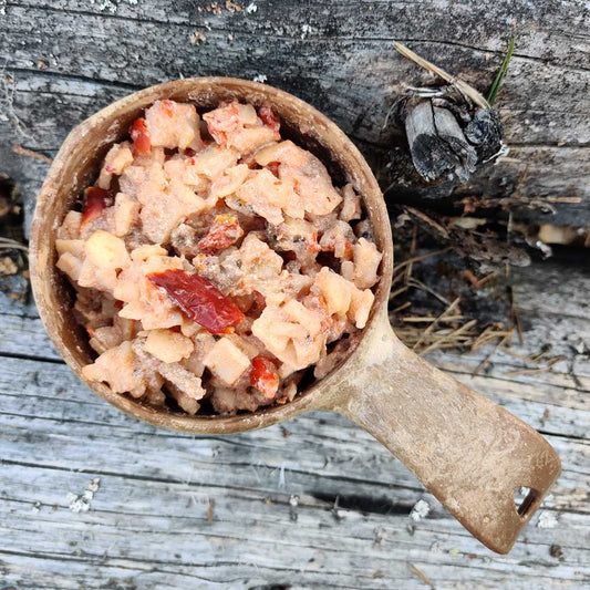 Baskilainen naudanlihapata espelette-pippurilla Kupilka-astiassa kelopuun päällä.