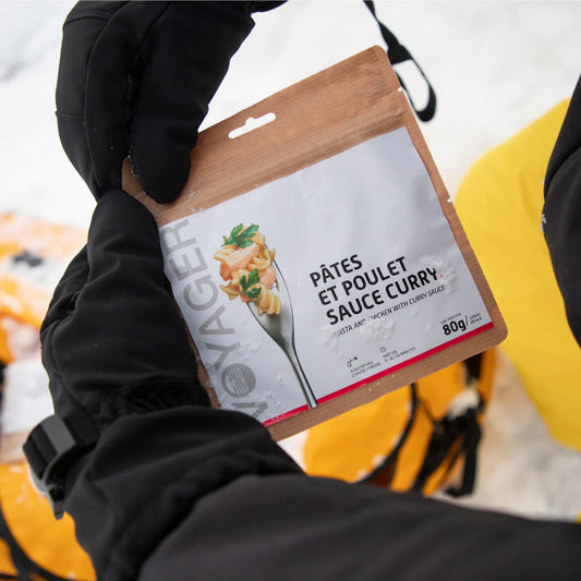 Kanapasta currykastikkeessa retkiruoka kierrätettävässä pussissa talvella käsissä.