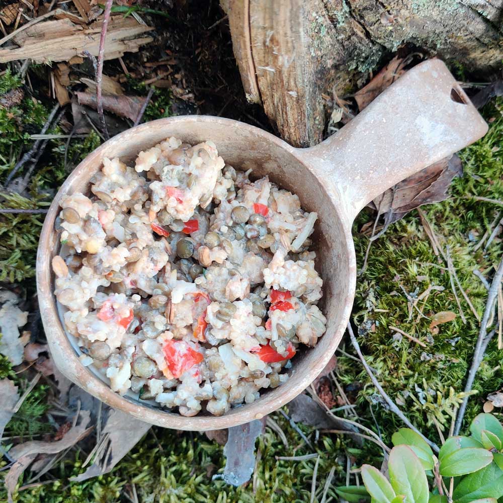 Kvinoa-linssipata retkiruoka Kupilka-astiassa sammaleen päällä.