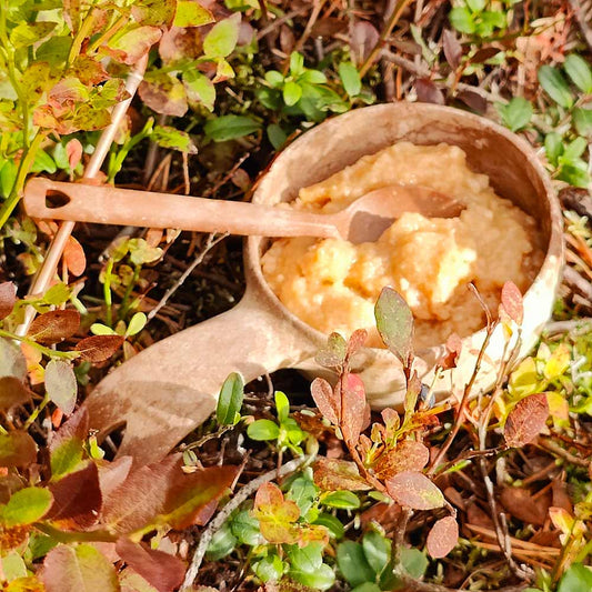 Omena-banaanipaistos Kupilka-astiassa ruskaisten varpujen keskellä.