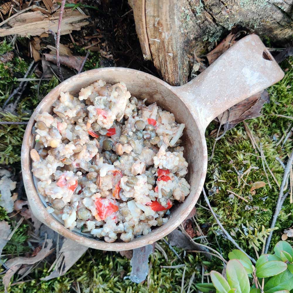Kvinoa-linssipata retkiruoka Kupilka-astiassa sammaleen päällä.